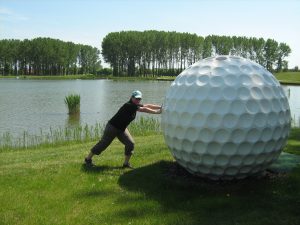 Mona Zett auf dem Golfplatz in Bük beim Versuch, das Grennkeeper-Häuschen in Form eines riesigen Golfplatzes wegzuschieben. 